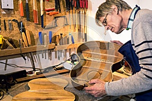 Luthier checking the body of an acoustic guitar