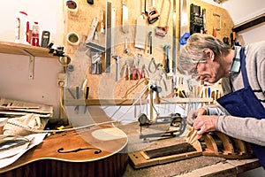 Luthier concentrating on carving a lute