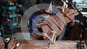 Luthier creating a guitar, clamps on the body of a guitar under construction improving glue adhesion