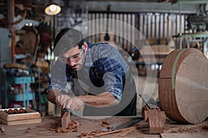 Luthier creating a guitar and using tools in a traditional