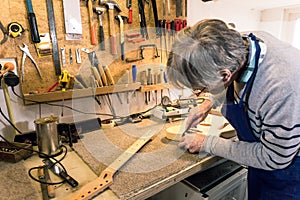 Luthier filing the neckpocket of an electric guitar