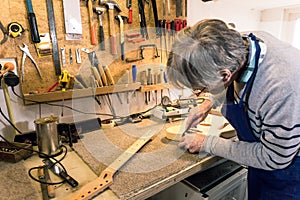 Luthier filing the neckpocket of an electric guitar photo