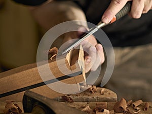 Luthier makes a neck block on classical guitar.