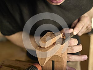 Luthier makes a neck block on classical guitar.