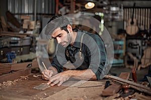 Luthier making a peghead of classical guitar