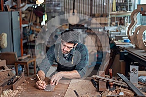 Luthier making a peghead of classical guitar