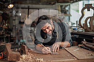 Luthier making a peghead of classical guitar