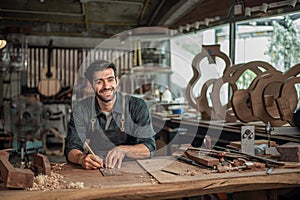 Luthier making a peghead of classical guitar