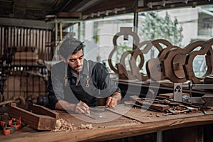 Luthier making a peghead of classical guitar