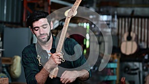 Luthier making wooden musical and using traditional tools in workroom with manual tools