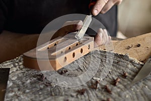 Luthier modifies the head of classical guitar.