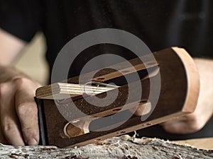 Luthier modifies the head of classical guitar.
