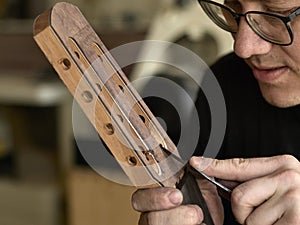 Luthier modifies the head of classical guitar.