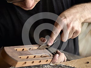 Luthier modifies the head of classical guitar.