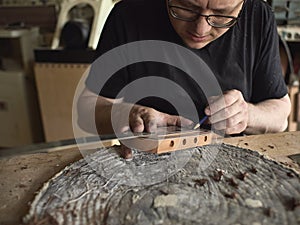Luthier modifies the head of classical guitar.