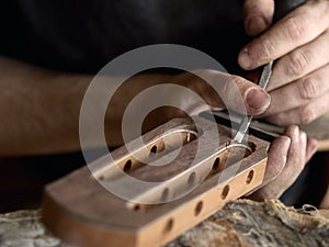 Luthier modifies the head of classical guitar.