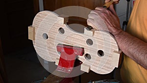 Luthier working with a chisel in the structure of a new viola or violin