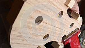 Luthier working with a chisel in the structure of a new violin