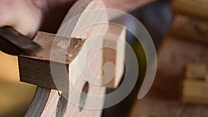 Luthier working with a chisel in the structure of a new violin or viola