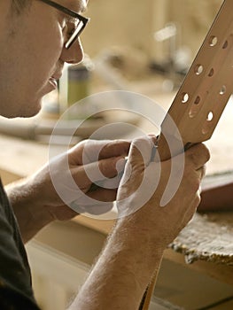 Luthier is working on the neck of classical guitar. photo