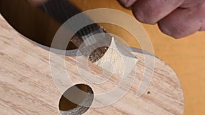 Luthier working in the structure of a new violin or viola in the workplace