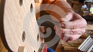 Luthier working in the structure of a new violin or viola in the workplace