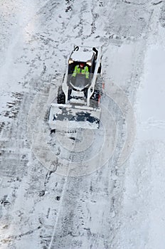 Lutsk, Ukraine - December 2, 2020. Bobcat skid steer loader removes snow from the city streets. Top view of the road with cars and