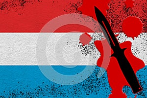 Luxembourg flag and black tactical knife in red blood. Concept for terror attack or military operations with lethal outcome