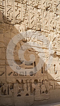 Luxor Egypt Karnak temple sandstone craved hieroglphic wall and column pharoah anceint story