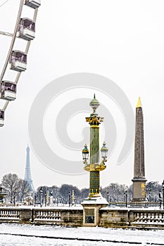 The Luxor obelisk and the Eiffel tower on a snowy day in Paris, France