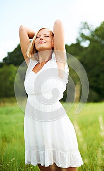 Luxuriating in the moment. Beautiful young woman standing outdoors enjoying the country air.