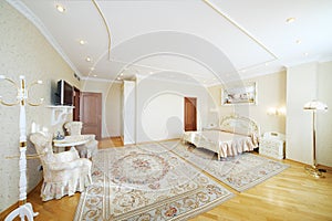 Luxurious bedroom with beautiful double bed, with armchairs
