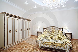 Luxurious bedroom with gilt double bed and wardrobe