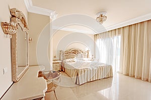 Luxurious bedroom in pastel colours in a neoclassical style, wit