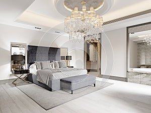 Luxurious bedroom with white walls and a gray fabric bed with black bedside tables and lamps and a large luminous crystal