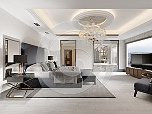 Luxurious bedroom with white walls and a gray fabric bed with black bedside tables and lamps and a large luminous crystal