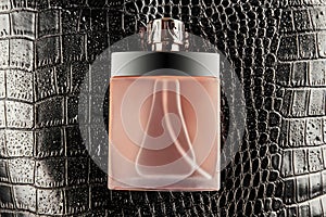 Luxurious bottle of perfume on black crocodile skin texture