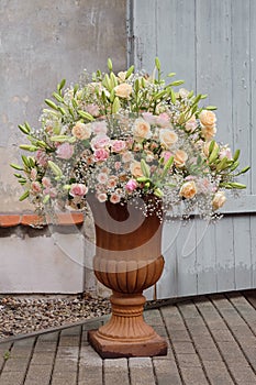 Luxurious bouquet of roses, lilies and gypsophila in a classic large vase