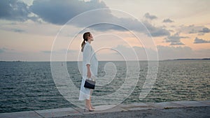 Luxurious businesswoman looking sea view standing on embankment calm evening.