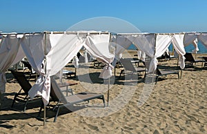 Luxurious cabins for sunbathing with sunbeds on the sandy beach