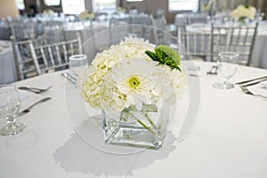 luxurious centerfold vase with white and green flowers at a beautiful event on a yacht or indoor space