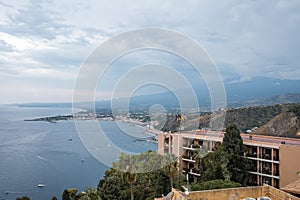 Idyllic view of Hotel Elios and Mount Etna by seascape with sky in background photo