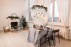 Luxurious expensive light interior in a royal style decorated with table, tree and fireplace