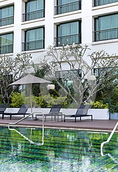 Luxurious hotel swimming pool with chairs and umbrella a clear water poolside view