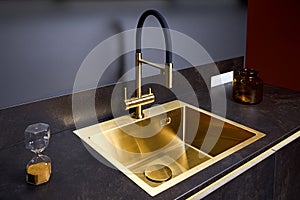 Luxurious interior square golden brass sink and faucet double tap mixer in contemporary modern design with stone marble