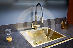 Luxurious interior square golden brass sink and faucet double tap mixer in contemporary modern design with stone marble