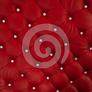 Luxurious leather soft sofa close-up. Stylish red material is decorated with brilliant buttons photo