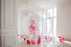 Luxurious living room with large window to the floor. Palace is filled with pink balloons