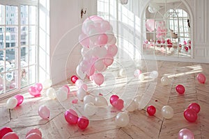 Luxurious living room with large window to the floor. Palace is filled with pink balloons. nobody