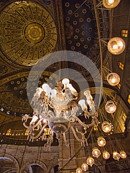 the chandelier and ornate ceiling of a church with large lights hanging from it